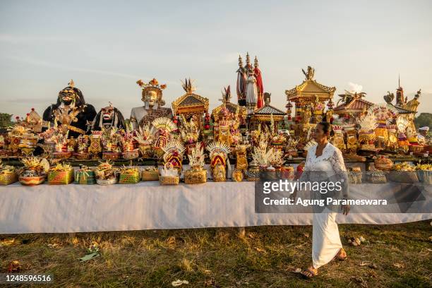 Balinese Hindus woman walks inform of the offerings during Melasti Ritual prior to Nyepi Day on March 19, 2023 at Siyut Beach, in Gianyar Bali,...