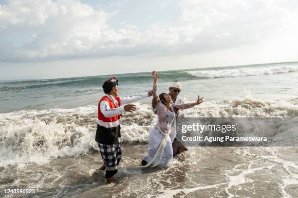 Balinese Hindus woman in a state of trance, dances during Melasti Ritual prior to Nyepi Day on March 19, 2023 at Batubolong Beach, in Canggu Bali,...