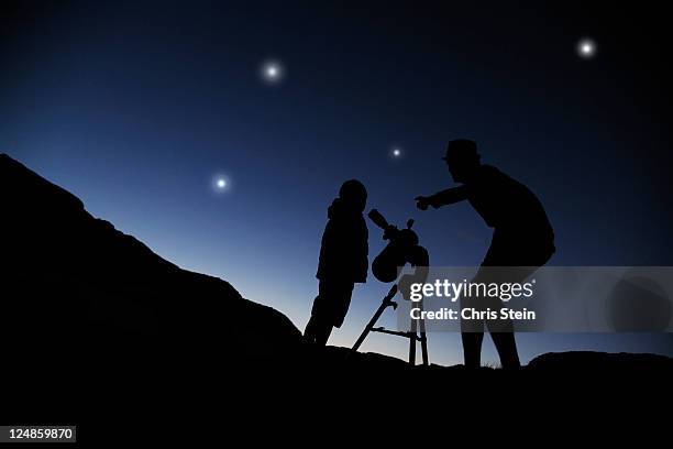 father and son looking through a telescope at nigh - starry nigh stock pictures, royalty-free photos & images