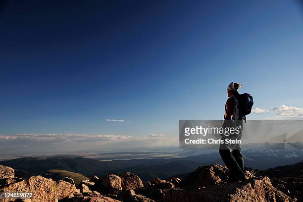 man stands alone on top of a mountain - denver stock-fotos und bilder
