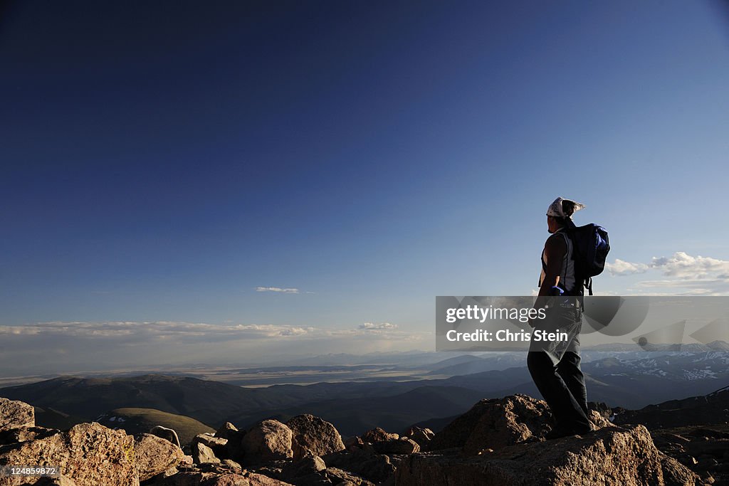 Man stands alone on top of a mountain