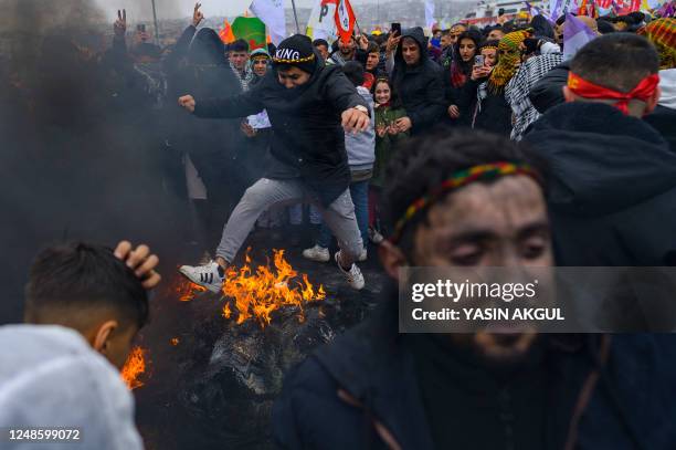 Man jumps over a bonfire during a Kurdish celebration of Nowruz , the New Year of the Persian calendar, in Istanbul on March 19, 2022.