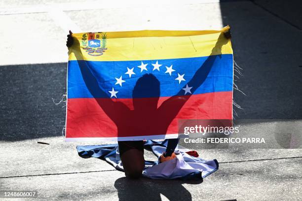 Venezuelan runner Magaly Garcia holds a Venezuelan flag after winning first place in the 42 km race of the 7th edition of the CAF Marathon in Caracas...