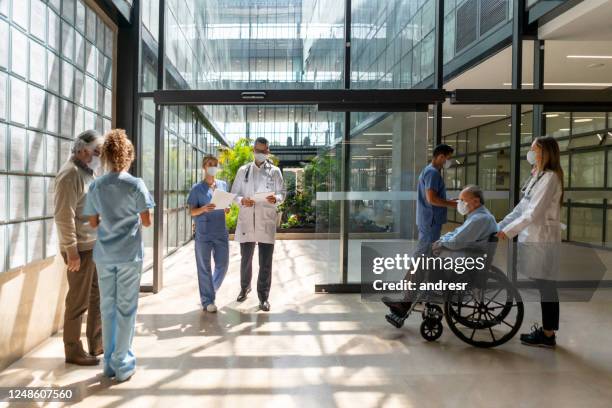 menschen, die ins krankenhaus ein- und aussteigen - krankenhaus eingang stock-fotos und bilder