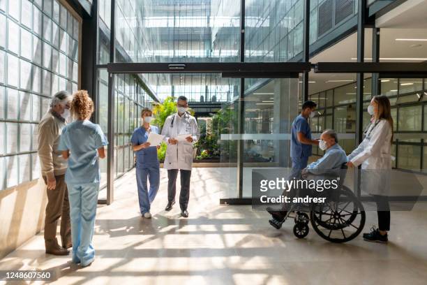 people walking in and out of the hospital - built structure stock pictures, royalty-free photos & images