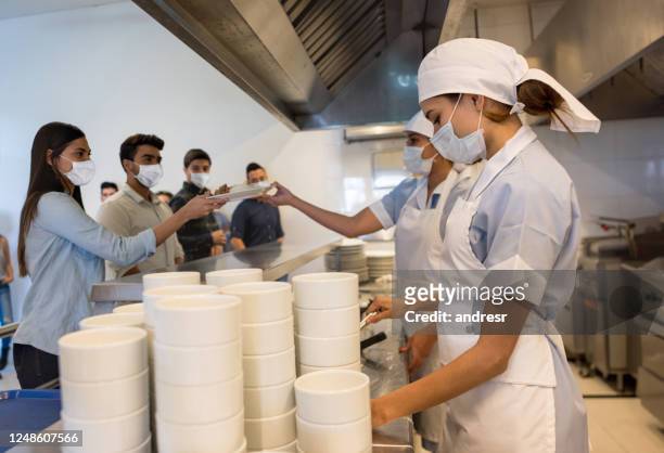 women working at a buffet restaurant serving the customers wearing facemasks - hospital food stock pictures, royalty-free photos & images