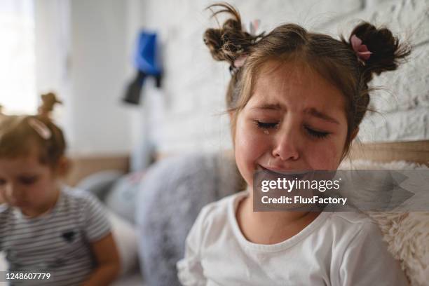fille triste pleurant dans sa chambre - larme photos et images de collection