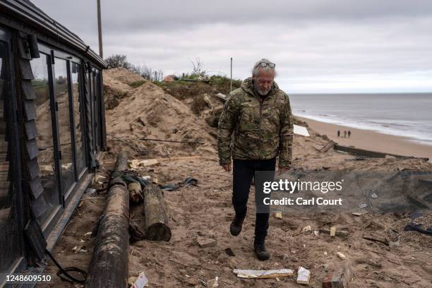 Lance Martin walks next to his bungalow after he dragged it around 3 metres inland from the edge of an eroding cliff to avoid a council demolition...