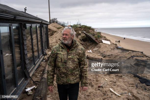 Lance Martin walks next to his bungalow after he dragged it around 3 metres inland from the edge of an eroding cliff to avoid a council demolition...
