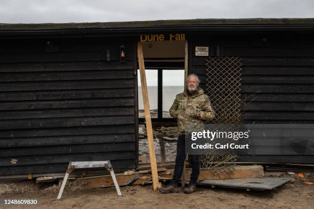 Lance Martin poses for a photograph next to his bungalow after he dragged it around 3 metres inland from the edge of an eroding cliff to avoid a...