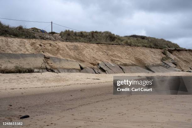 Section of road lies on the beach after the cliff eroded, on March 19, 2023 in Hemsby, England. Coastal erosion here has destroyed several homes and...