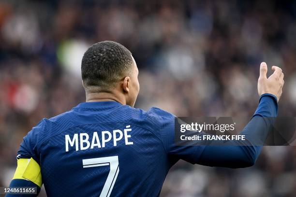 Paris Saint-Germain's French forward Kylian Mbappe wearing the captain armband enters the pitch prior to the French L1 football match between Paris...