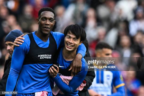 Brighton's English striker Danny Welbeck celebrates with Brighton's Japanese midfielder Kaoru Mitoma at the end of the English FA Cup quarter-final...