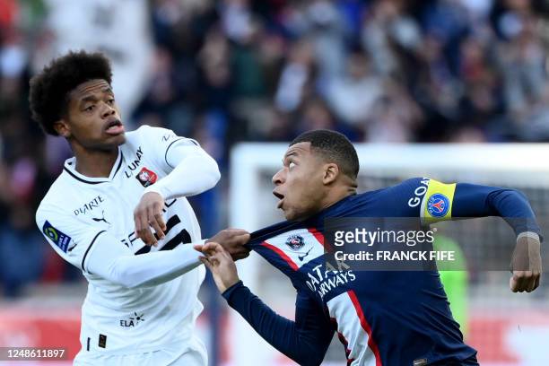 Rennes' French defender Warmed Omari pulls jersey of Paris Saint-Germain's French forward Kylian Mbappe during the French L1 football match between...