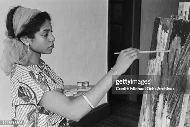 Nigerian artist and arts promoter Afi Ekong as she paints on a canvas, Lagos, Nigeria, January 1962.