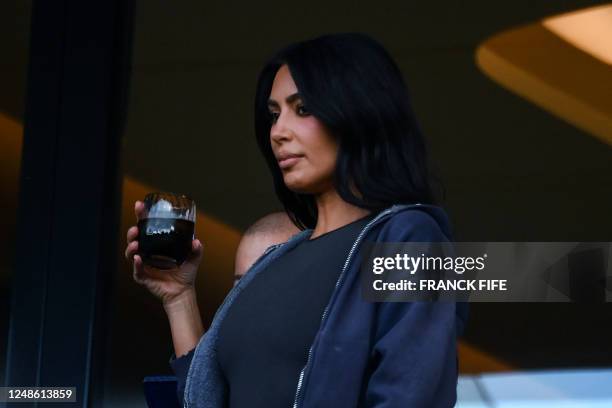 Media personality and socialite Kim Kardashian holds a glass as she attends the French L1 football match between Paris Saint-Germain and Stade...