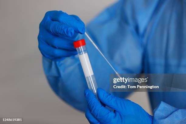 Doping Control Officer Deke Gunsolley displays a swab as he explains the coronavirus testing process at a mobile testing unit prior to the Charles...