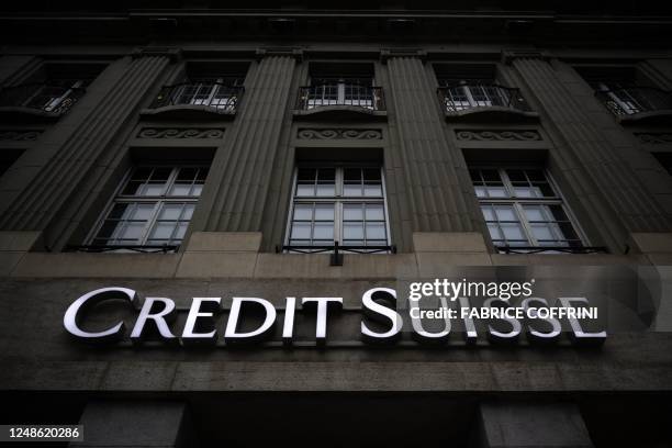 This photograph taken on March 19 shows the logo of Swiss banking Credit Suisse on a building facade in Bern. - UBS was up against the clock on March...