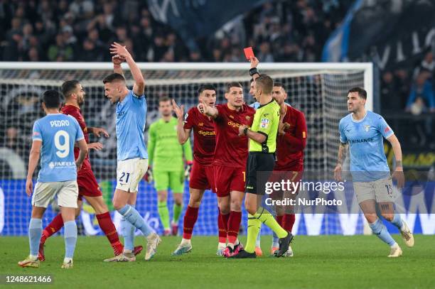 Referee Davide Massa shows a red card to Roger Ibanez of AS Roma during the Serie A match between SS Lazio and AS Roma at Stadio Olimpico, Rome,...