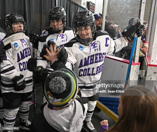 Leslie Schwartz of Amherst College high fives a young fan before the Mammoths take the ice to face Gustavus Adolphus during the Division III Womens...