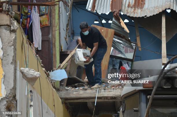 Neighbours recover some belongings the day after an earthquake in Machala, Ecuador, on March 19, 2023. - According to an official toll on Sunday, the...