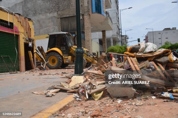 Worker removes debris from buildings the day after an earthquake in Machala, Ecuador, 19 March 2023. - According to an official toll on Sunday, the...