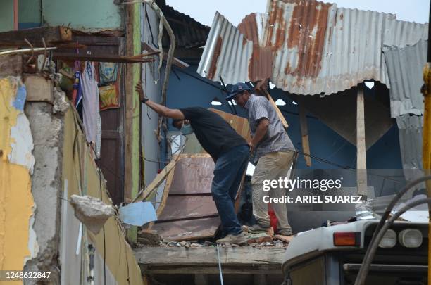 Neighbours recover some belongings the day after an earthquake in Machala, Ecuador, on March 19, 2023. - According to an official toll on Sunday, the...