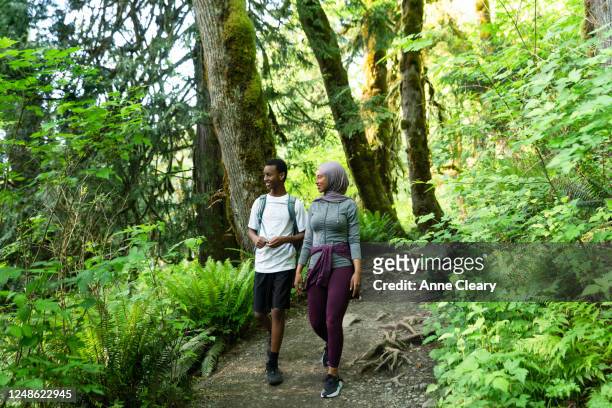 Smiling woman hiking through forest with brother