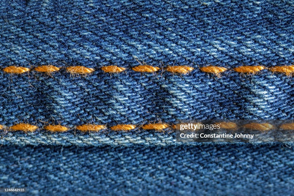 Close Up of Golden Stitches on Blue Denim Jeans