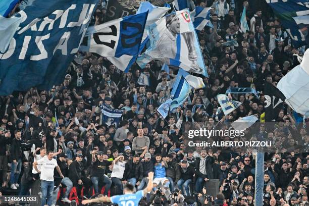 Lazio's Italian midfielder Mattia Zaccagni joins Lazio fans in a tribune to celebrate at the end of the Italian Serie A football match between Lazio...