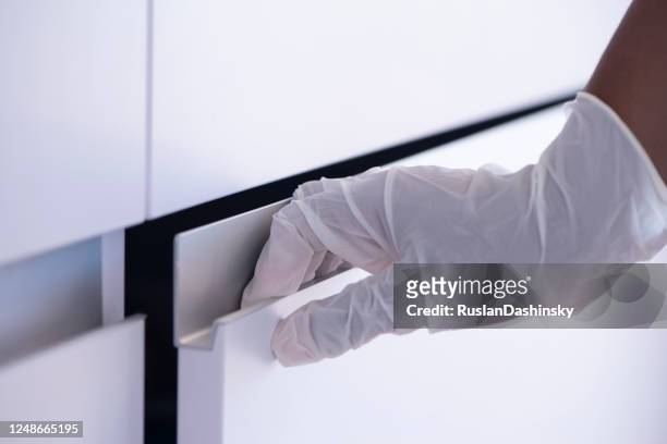 opening / closing cabinet door. female's hand in surgical glove touching drawer door aluminum handle. - right hand stock pictures, royalty-free photos & images