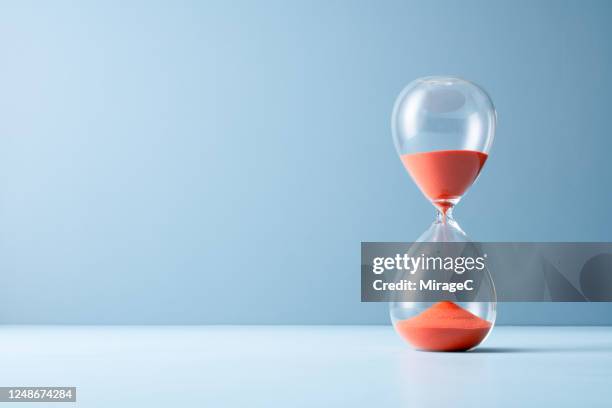 orange sand hourglass - hourglass stock pictures, royalty-free photos & images
