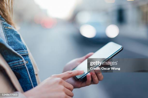 woman booking a taxi using mobile app on smartphone - finger dialing touch tone telephone stock pictures, royalty-free photos & images