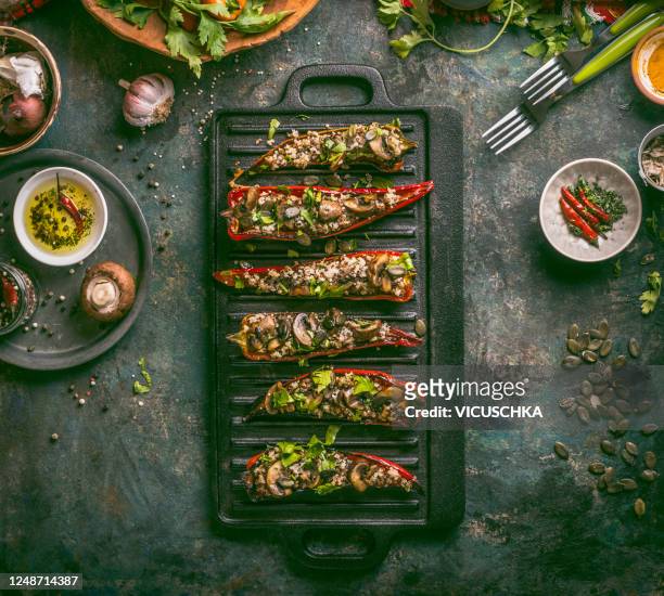 grilled paprika halves stuffed with quinoa and mushrooms , topped with pumpkin seeds and fresh chopped herbs - griddle stock pictures, royalty-free photos & images