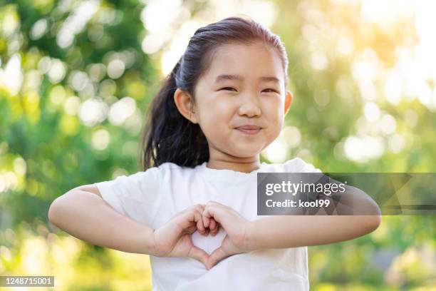 little girl making heart shaped gesture - child love heart hands stock pictures, royalty-free photos & images