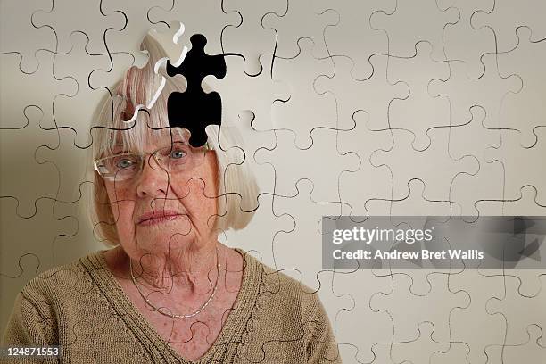 jigsaw puzzle, of a senior woman, falling apart - alzheimer's disease stockfoto's en -beelden