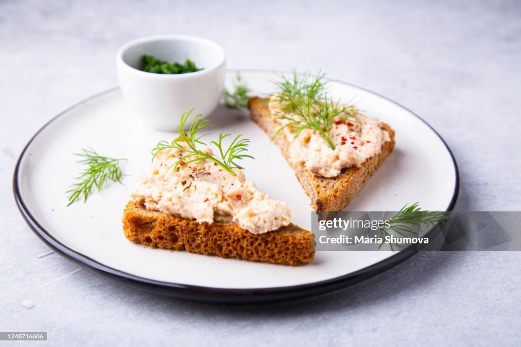 Two open sandwiches with fish mousse garnished with fresh dill