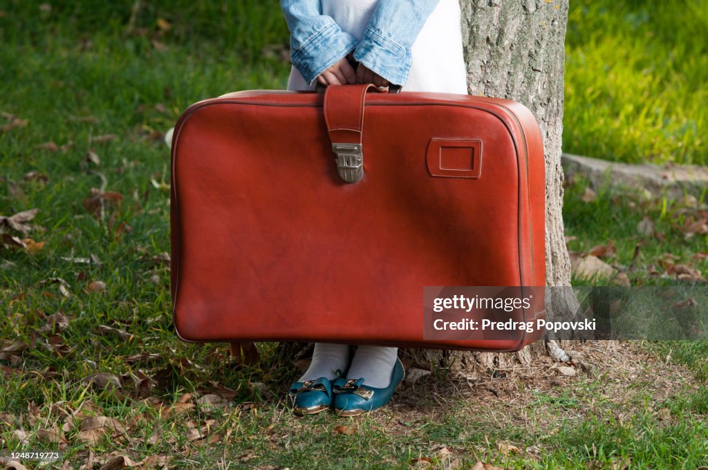Closeup image of little child holding suitcase with space for text