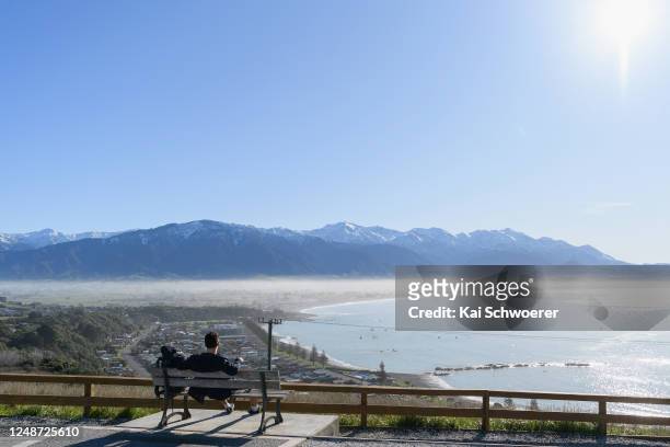 Backpacker enjoys the view of Kaikoura and the Kaikoura Ranges on June 10, 2020 in Kaikoura, New Zealand. New Zealanders are adjusting as life begins...