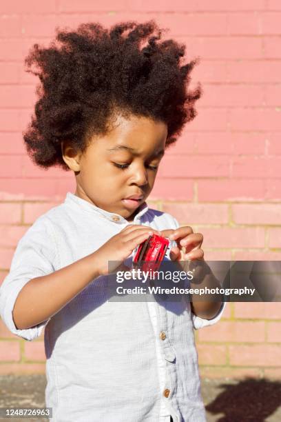toddler holding a red car - red shirt stockfoto's en -beelden