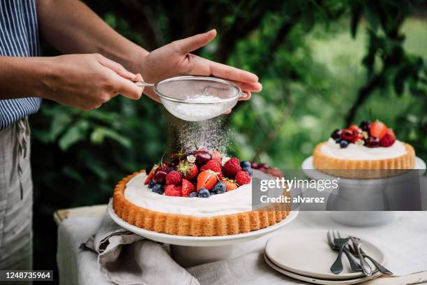 woman preparing fresh fruits and berries cake - sifting powdered sugar stock pictures, royalty-free photos & images