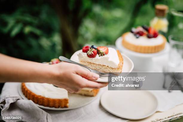 frau serviert köstlichen obstkuchen - cremetorte stock-fotos und bilder