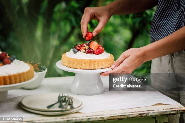 weibchen bereiten obstkuchen zum frühstück - cremetorte stock-fotos und bilder