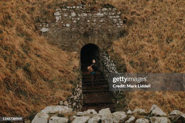 man entering the ruins of dunnottar castle, scotland - dunnottar castle 個照片及圖片檔