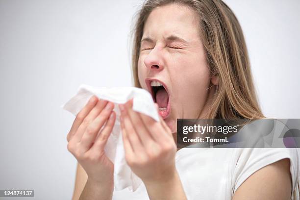 jovem mulher sneezing - espirrando - fotografias e filmes do acervo