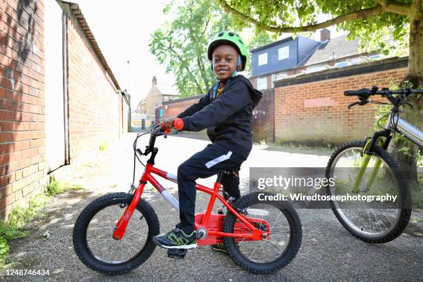 boy on a red bike wearing a helmet - kids on bikes stock pictures, royalty-free photos & images