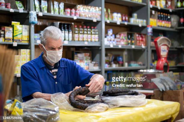 senior man in his small grocery store. antique balance weight - tobacconists stock pictures, royalty-free photos & images