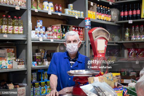 homme aîné dans sa petite épicerie. poids d’équilibre antique - mini grocery store photos et images de collection