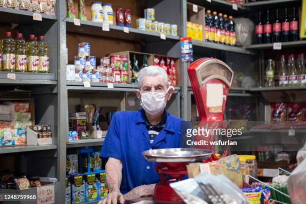 uomo anziano nel suo piccolo negozio di alimentari. peso dell'equilibrio antico - piccolo foto e immagini stock