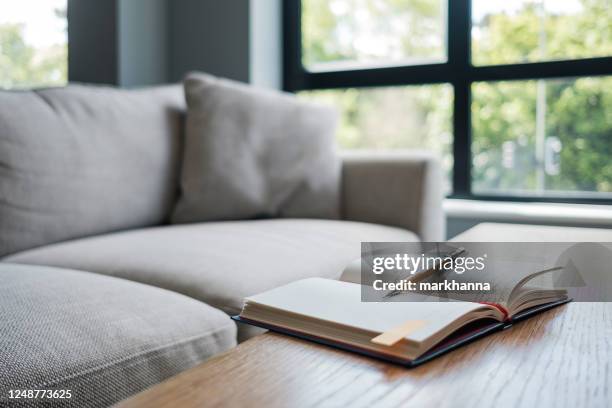 open notebook on a living room table - book on table stock pictures, royalty-free photos & images